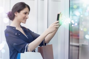 Young businesswoman looking at smartphone with lights coming out of it
